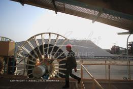 Image du Maroc Professionnelle de  Un agent de sécurité contrôle les installations du Stacker dans la Zone du stockage du phosphate lavé au complexe pétrochimique de Safi de L'Office chérifien des phosphates (OCP) datant des années 60. Dans cette unité on produit de l'acide phosphorique et des engrais. Le Groupe OCP est une société anonyme fondée en 1920 et domiciliée au Maroc. OCP S.A est le Leader mondial de l'industrie du phosphate, Mardi 28 Août 2007. (Photo / Abdeljalil Bounhar) 